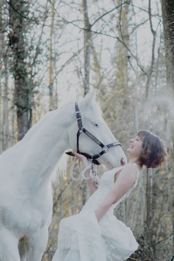 Photo de mariage fun avec un cheval blanc